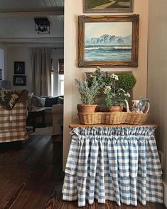 there is a basket with plants on top of it in the corner of this room