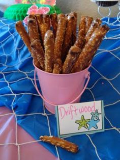 a bucket full of pretzels sitting on top of a blue net tablecloth