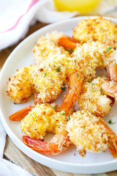 a white plate topped with fried shrimp and broccoli covered in parmesan cheese