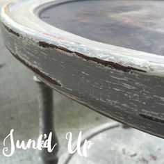 an old wooden table with peeling paint on it's top and metal legs,