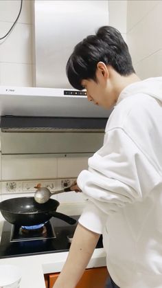 a young man cooking on top of a stove