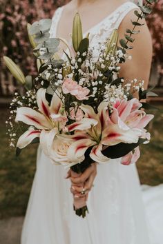 a woman holding a bouquet of flowers in her hands