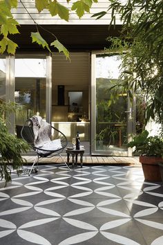 a patio with a chair and potted plants