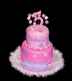 a pink birthday cake with flowers and the number five on it