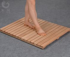 a person standing on top of a wooden mat with their bare feet resting on it