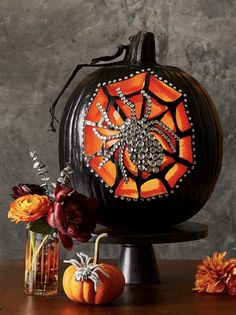 a pumpkin decorated with jewels and flowers on a table