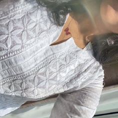 a woman in white shirt leaning on the back of a car