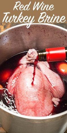 red wine is being poured into a pot filled with turkey