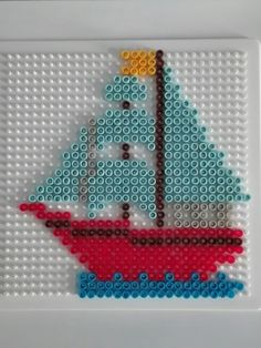 a cross - stitch picture of a sailboat made out of legos