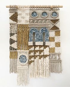 the wall hanging is made up of different types of beads and fringes, including one with