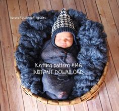 a newborn baby wrapped in a blanket and wearing a knitted hat is posed in a basket