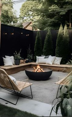 an outdoor fire pit surrounded by chairs and trees