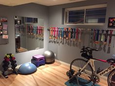 there is a bike and exercise balls in the room with mirrors on the wall above it