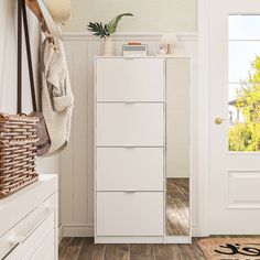 a white chest of drawers sitting in a room next to a door with a hat hanging on it