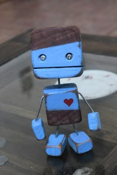 a wooden toy robot sitting on top of a table