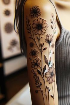 a woman's arm with flowers and leaves painted on the back of her body