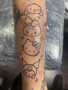 a person with a hello kitty tattoo on their arm