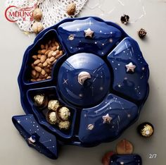 a blue bowl filled with assorted chocolates and nuts