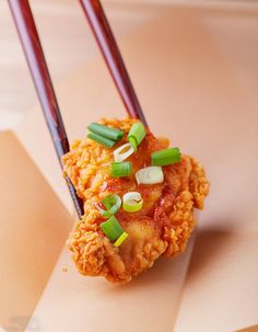 two chopsticks sticking out of some food on top of a piece of paper