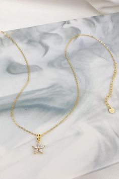 This is a fine chain necklace which is made from 18 karat gold-plated sterling silver and which features a small flower-shaped charm with five, clear-colored Marquise-cut zircon gemstones in a five-prong setting. The chain closes at the center back with a round spring clasp, and it also has an extension chain (made from larger chain links), which makes the whole thing adjustable. Delicate, classy, and a little bit feminine, this necklace will look stunning paired with anything from a boxy linen Dainty Rose Gold Flower Necklace, Dainty Rose Gold Flower Necklace With Delicate Chain, Delicate Clavicle Chain Pendant Necklace, Dainty Flower Pendant Charm Necklace With Adjustable Chain, Delicate Charm Necklace With Flower Pendant And Adjustable Chain, Dainty Necklace With Delicate Chain And Flower Pendant, Dainty Flower Pendant Necklace With Delicate Chain, Gold Plated Flower Pendant Charm Necklace With Adjustable Chain, Elegant Gold Charm Necklace With Flower Detail