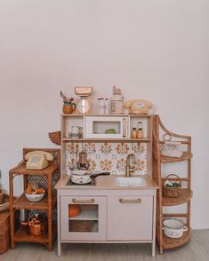 a toy kitchen with wooden furniture and accessories