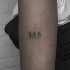 a person with a tattoo on their arm that has three small dogs in the middle