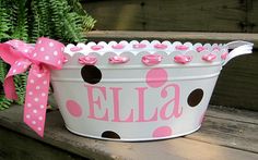 a white bucket with pink polka dots and a name on it