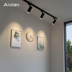 there are three pictures on the wall with lights