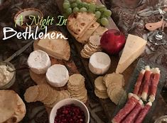 an assortment of cheeses, crackers and fruit on a table