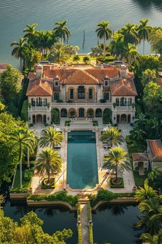 an aerial view of a mansion with a pool and palm trees in the foreground