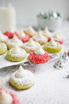 a table topped with lots of different types of cakes and pastries covered in powdered sugar