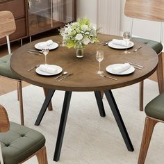 a round table with four chairs around it and a vase on the centerpiece in the middle