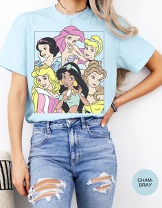 a woman with her hands on her hips wearing ripped jeans and a disney princess t - shirt