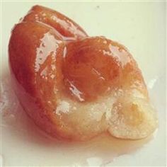 two glazed doughnuts sitting on top of each other in a white plate with icing