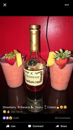 three glasses filled with fruit sitting next to a bottle