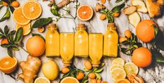 orange juice in bottles surrounded by citrus fruits