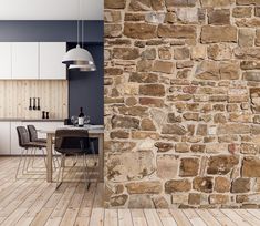 an empty kitchen and dining room with wood flooring, stone wall and white cabinets