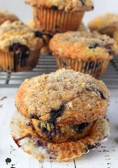 blueberry muffins cooling on a rack with other muffins in the background