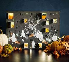 a table topped with lots of pumpkins next to a wall mounted calendar filled with pictures