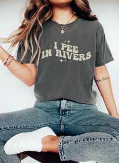 I pee in rivers. Funny graphic tee for river lovers. Comfort Colors brand shirt in Pepper color. Funny Letter Print T-shirt For Outdoor, Cotton Slogan Tops For Outdoor Activities, Casual T-shirt For Fall Outdoor Activities, River Tshirt Designs, Casual Outdoor Slogan T-shirt, Fall Hiking T-shirt With Graphic Print, Casual Outdoor T-shirt With Funny Text, Casual Text Print T-shirt For Hiking, Pepper Color