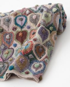 a multicolored crocheted blanket with hearts on it