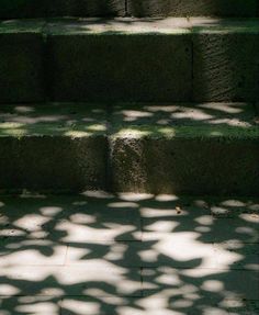 a red fire hydrant sitting on the side of some steps with shadows cast by it