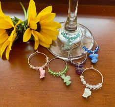 wine glass charms are sitting next to a sunflower