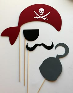 a cake topper with a pirate's hat and mustache on it, sitting next to some skewers