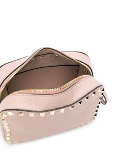 Powder pink leather Rockstud crossbody bag from Valentino featuring signature Rockstud detailing, pebbled texture, logo print to the front, top zip fastening, leather strap and internal slip pocket. | Valentino Garavani Rockstud crossbody bag Valentino Garavani Bag, Valentino Rockstud, Mini Crossbody Bag, Sneaker Heels, Powder Pink, Mini Crossbody, Handbag Shopping, Pink Leather, Mens Shoes Sneakers