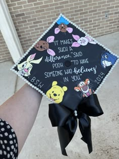 a person wearing a graduation cap with winnie the pooh on it