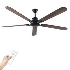 a person is holding a remote control in front of a ceiling fan with two blades