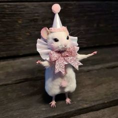 a little mouse wearing a party hat and bow