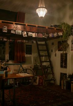 a loft bed with ladders and pictures on the wall