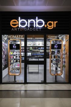 the entrance to an art and design store with its glass doors open at night time